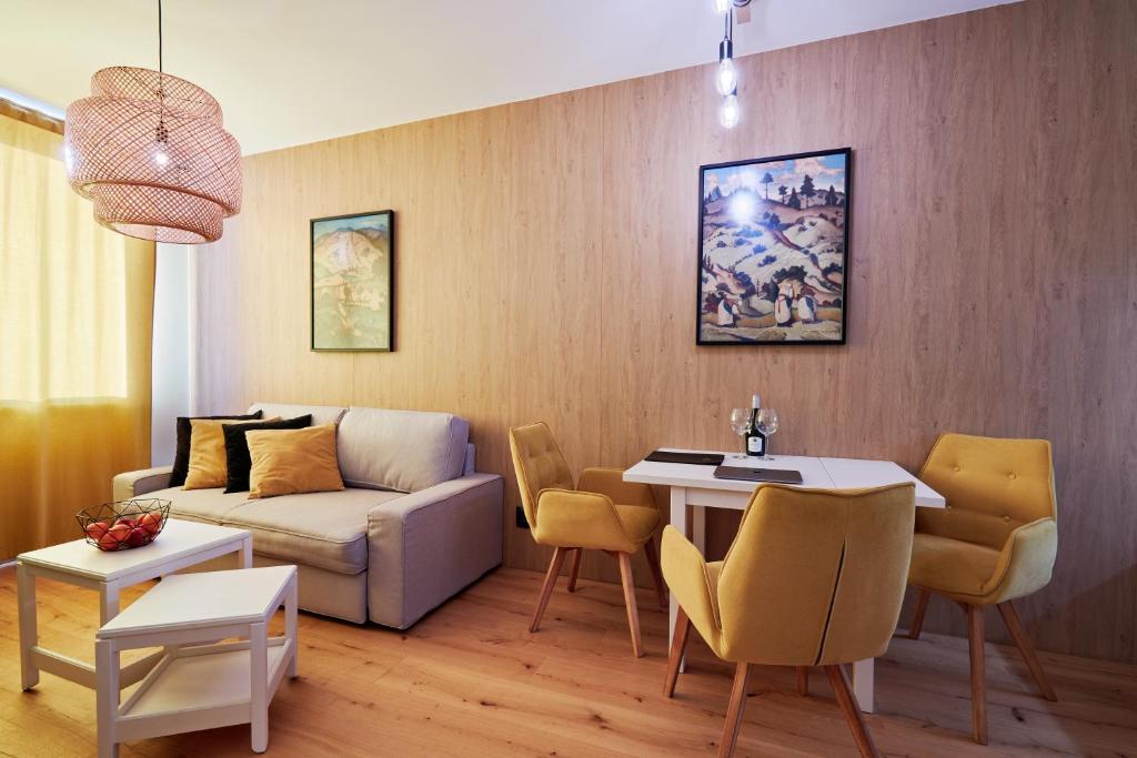 ein Wohnzimmer mit einem Sofa und einem Tisch in der Unterkunft RV Apartment Jantár in Starý Smokovec