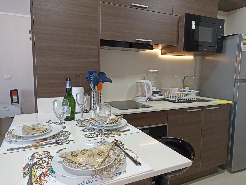 a kitchen with a table with plates and wine glasses at Departamento full a pasos de la playa in Viña del Mar