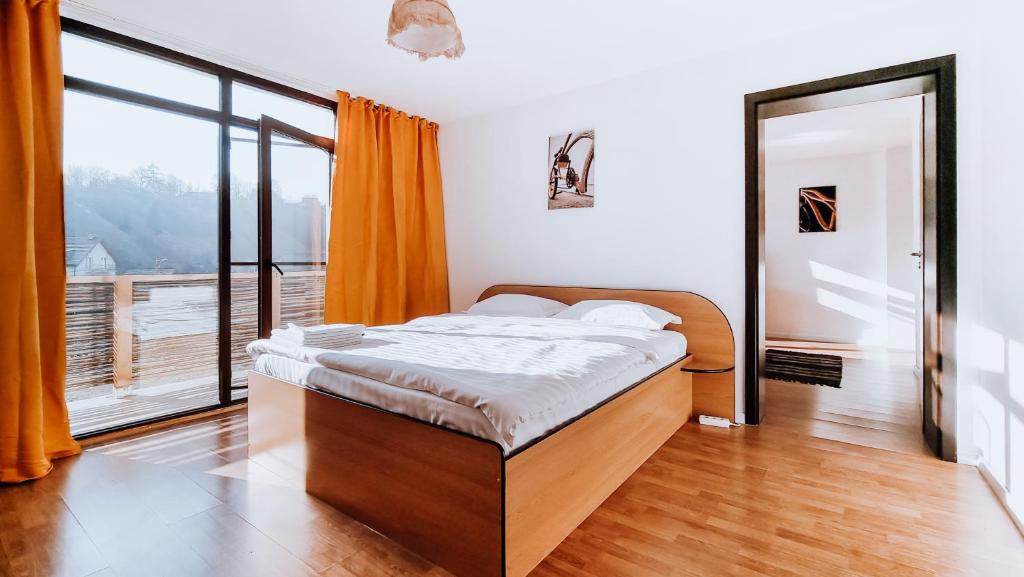 a bedroom with a bed and a large window at Pensiunea Bike&Bed in Moieciu de Jos
