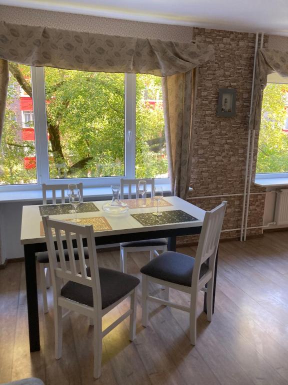 a dining room with a table and chairs and windows at Find for the traveler in Tallinn