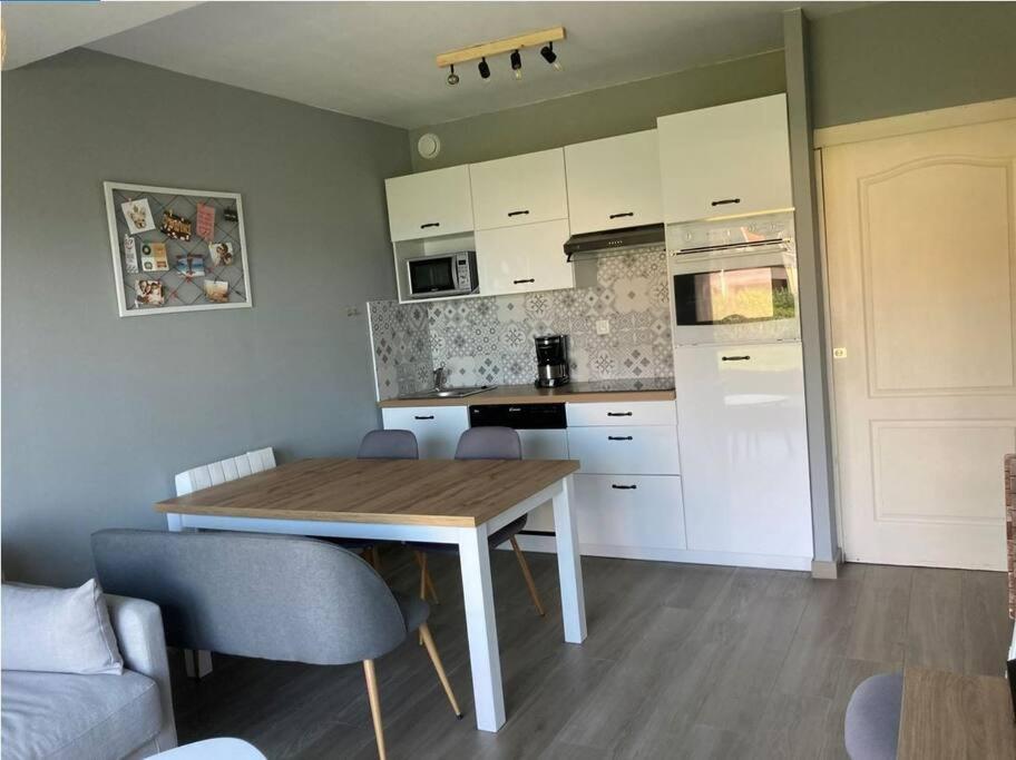 una cucina con tavolo in legno in una camera di Superbe appartement restauré avec vue sur mer. a Wimereux