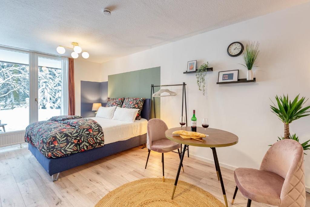 a bedroom with a bed and a table and chairs at Apartment Rio in Winterberg