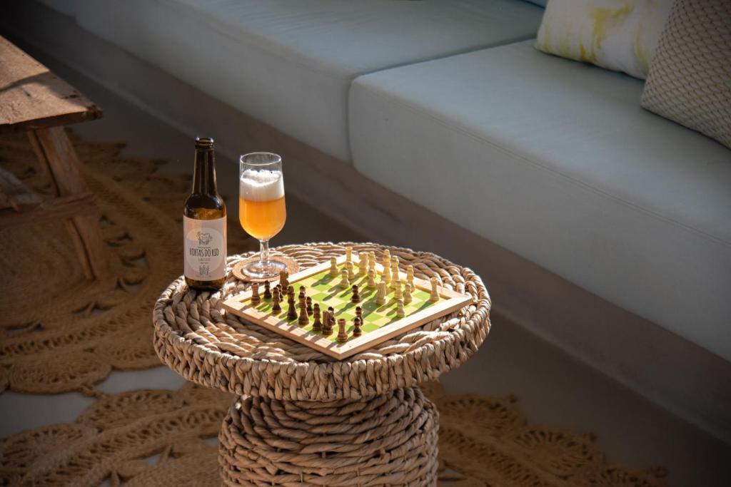 a table with a bottle and a glass of beer at Hortas do Rio - Casa de Campo in Carrapateira
