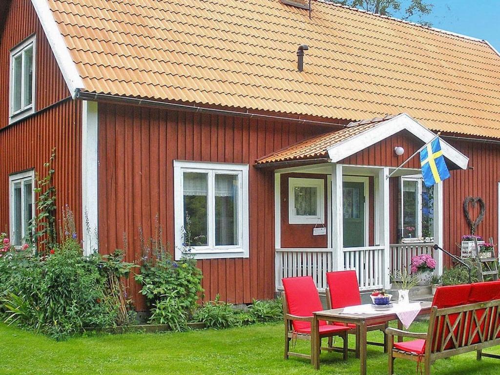 a red house with a table and chairs in front of it at 3 person holiday home in Tystberga in Tystberga