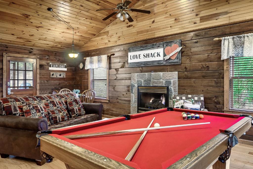 a pool table in a living room with a fireplace at Love Shack in Sevierville