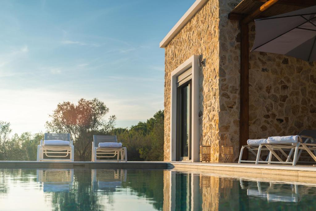 ein Haus mit einem Pool neben einem Gebäude in der Unterkunft Oliveto A Flumine - Experientia Villa in Pastida