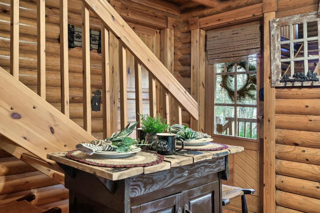 a dining table in a log cabin with a staircase at Gnome Alone in Sevierville