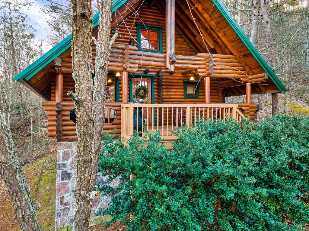 eine Blockhütte im Wald mit einer Veranda in der Unterkunft Gnome Alone in Sevierville