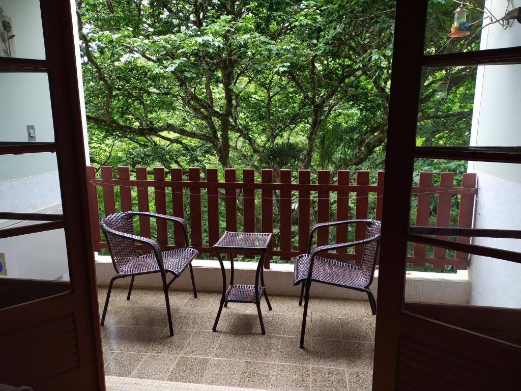 a patio with chairs and a table and a fence at Apartamento Bosque Águas de Lindóia in Águas de Lindoia