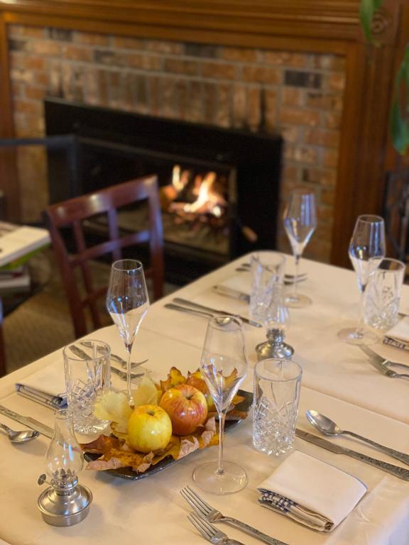 a table with wine glasses and fruit on it with a fireplace at Orcas Hotel in Orcas