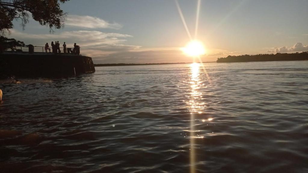 un grupo de personas viendo la puesta de sol en el agua en Paraiso de Aruanã - Rio Araguaia - Imóvel recém construído!! NOVÍSSIMO!!!! A PISCINA É AQUECIDA!!!, en Aruanã