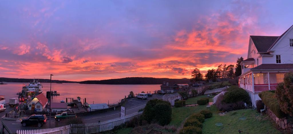a sunset over a body of water with a house at Orcas Hotel in Orcas