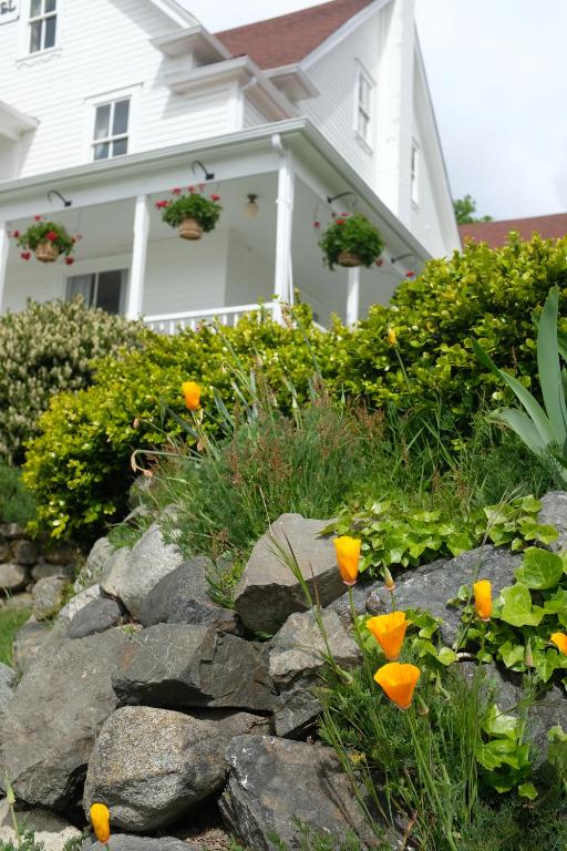 a house with a flower garden in front of it at Orcas Hotel in Orcas