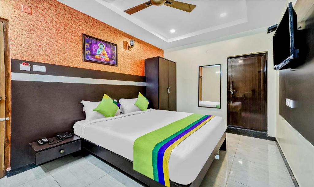 um quarto com uma cama e uma televisão em Treebo Trend Sripadha Residency Alipiri Road em Tirupati