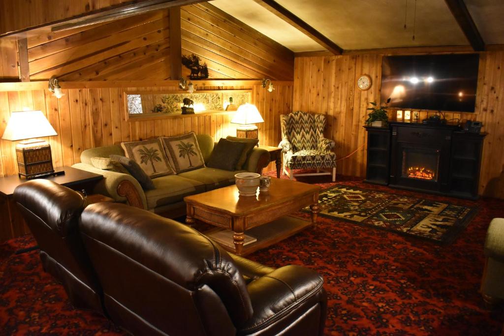 sala de estar con sofá de cuero y chimenea en Silver Horseshoe Inn en Saint Anthony