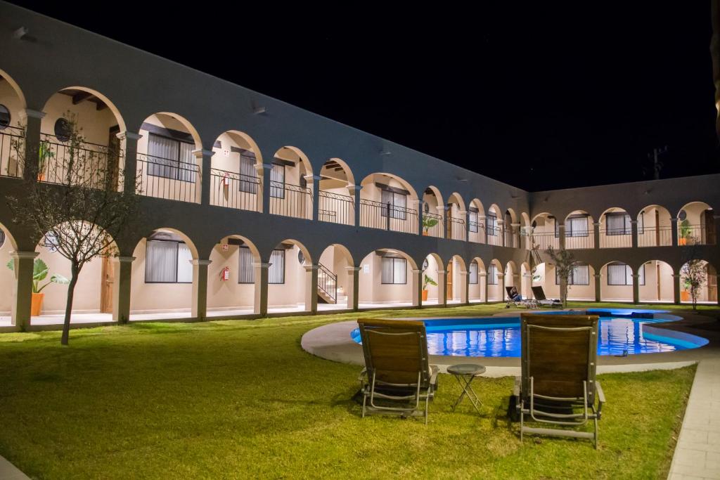 un patio con sillas y una piscina por la noche en Real de Corralejo, en San Miguel de Allende