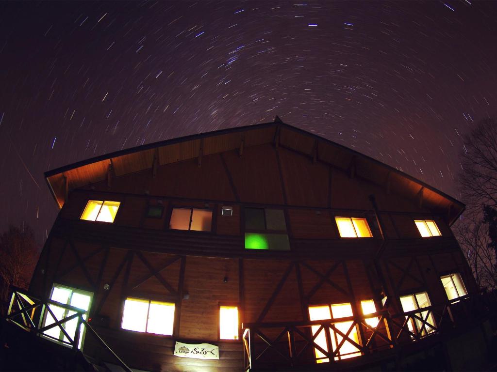 a building with lit windows at night at Lodge ぷるーく in Myoko