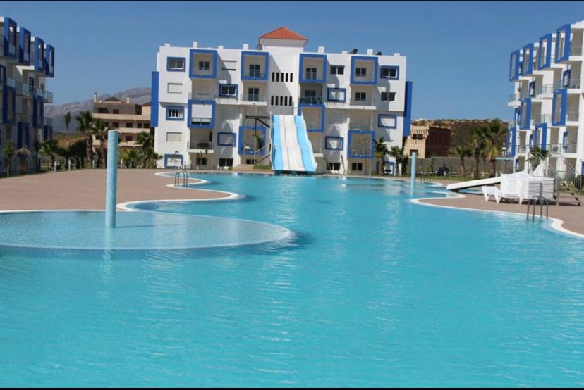 a swimming pool with a water slide in front of buildings at Kariat Cabo - Cabo Negro 32 in Cabo Negro