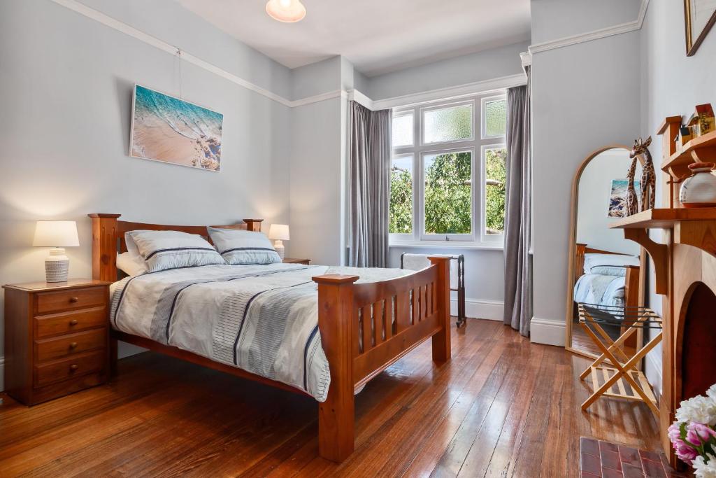 ein Schlafzimmer mit einem großen Bett und einem Fenster in der Unterkunft Warwick St Retreat! 3 Bedroom House With Parking in Hobart