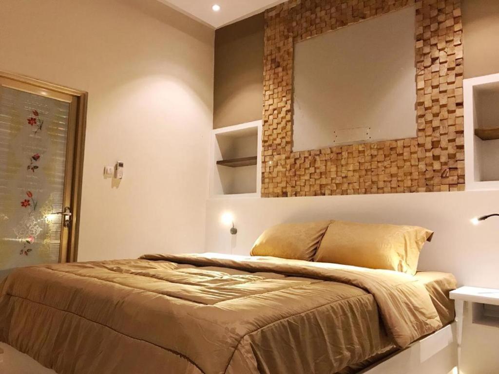 een slaapkamer met een bed en een spiegel aan de muur bij villa view2 sayriah in Puncak