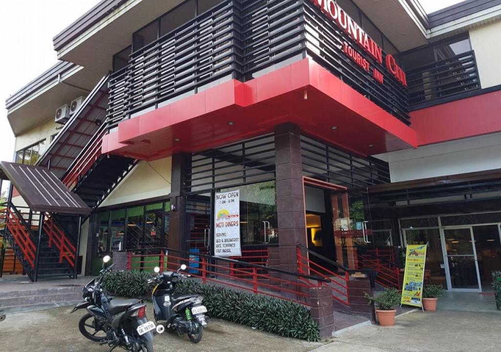 dos motocicletas estacionadas frente a un edificio en RedDoorz @ Mountain Citi Tourist Inn Canlaon en Panubigan