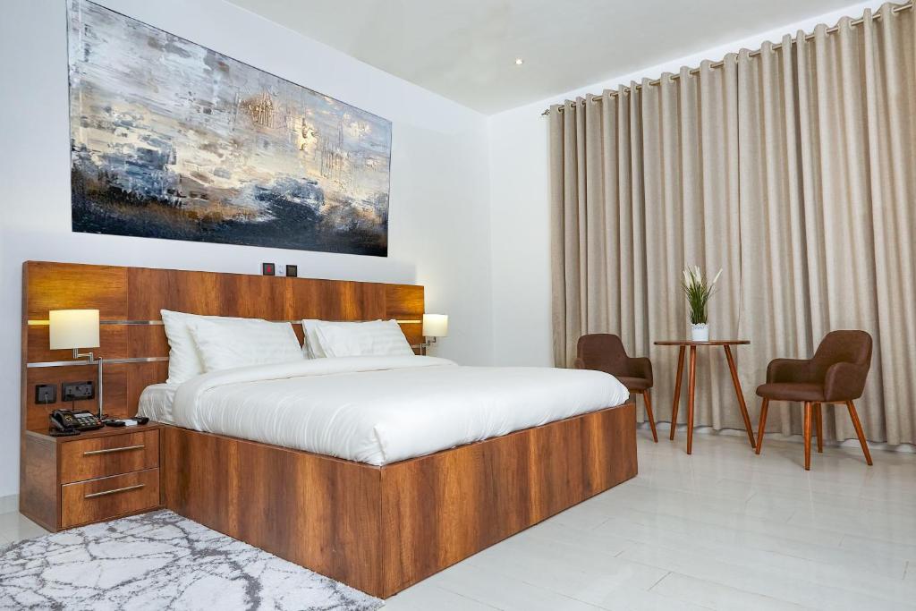 a bedroom with a large bed and a table and chairs at Maple Homes in Accra