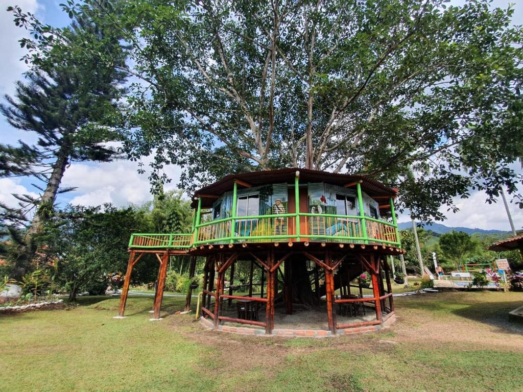 a tree house sitting in the middle of a field at Room in Lodge - Tree House Finca La Floresta Verde in Rizaralda