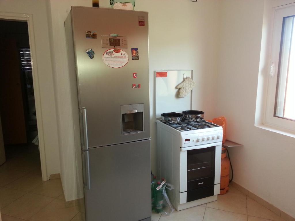 uma cozinha com um frigorífico e um fogão em Apartments Nada em Utjeha
