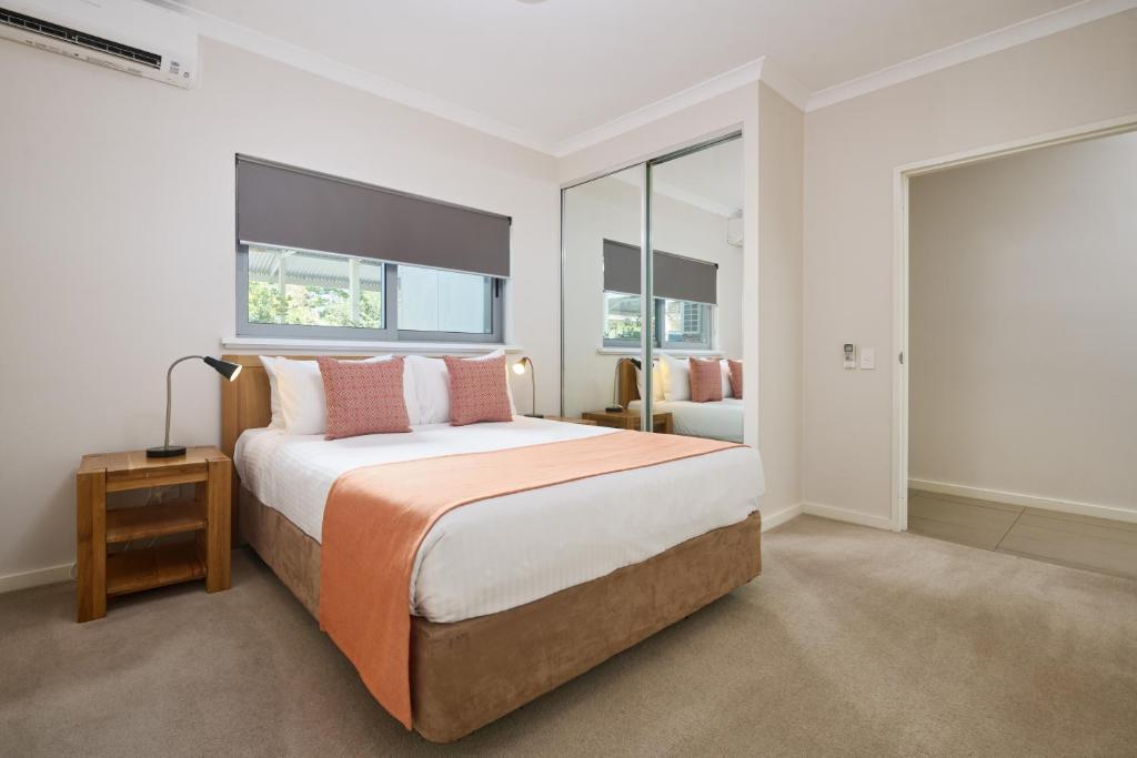 een slaapkamer met een groot bed en een raam bij Airport Apartments by Vetroblu in Perth