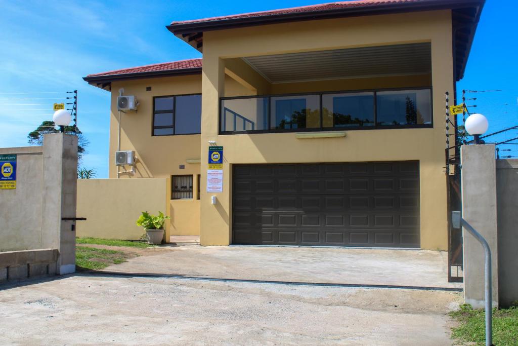 a house with a garage door in a driveway at Langelihle- Margate Accommodation in Margate