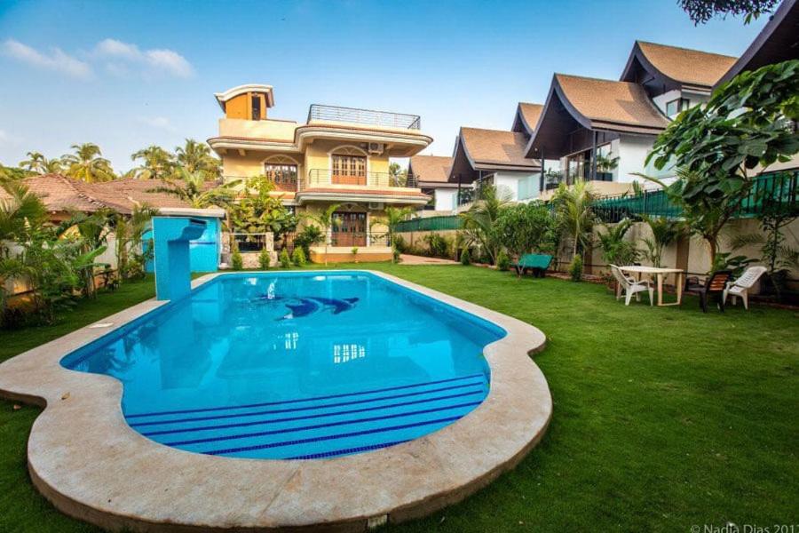 a large swimming pool in the yard of a house at Villa De Goa- Baga Creek in Baga