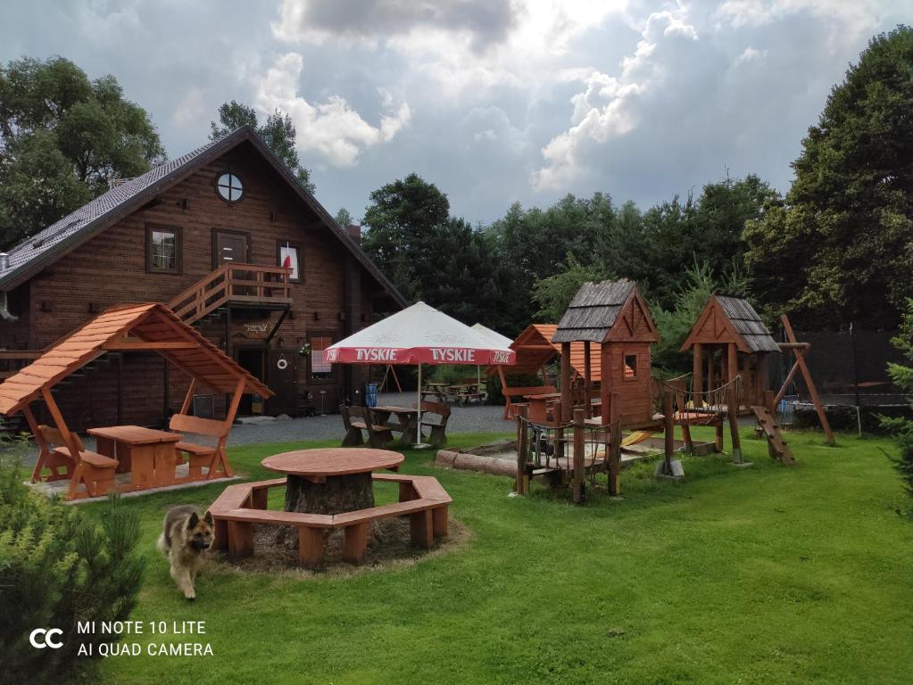a group of play structures in front of a barn at Apartament "Cichy kącik" in Lubawka