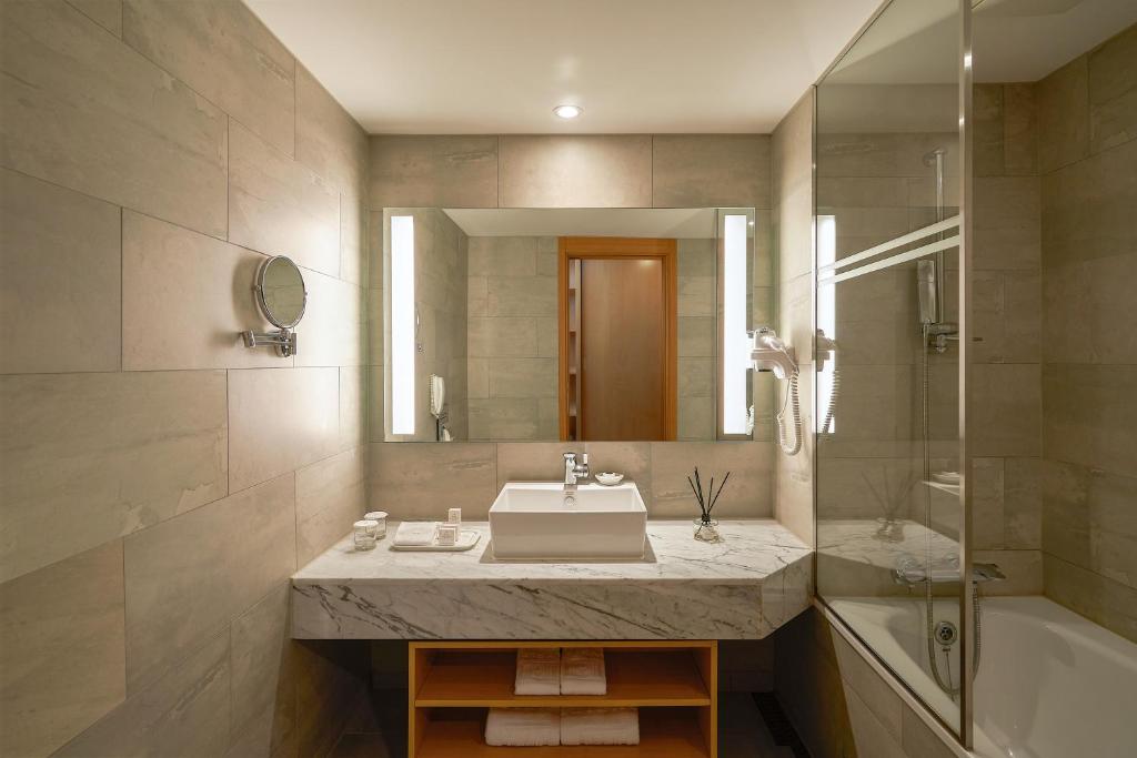 a bathroom with a sink and a tub and a mirror at Mayfield Hotel Seoul in Seoul