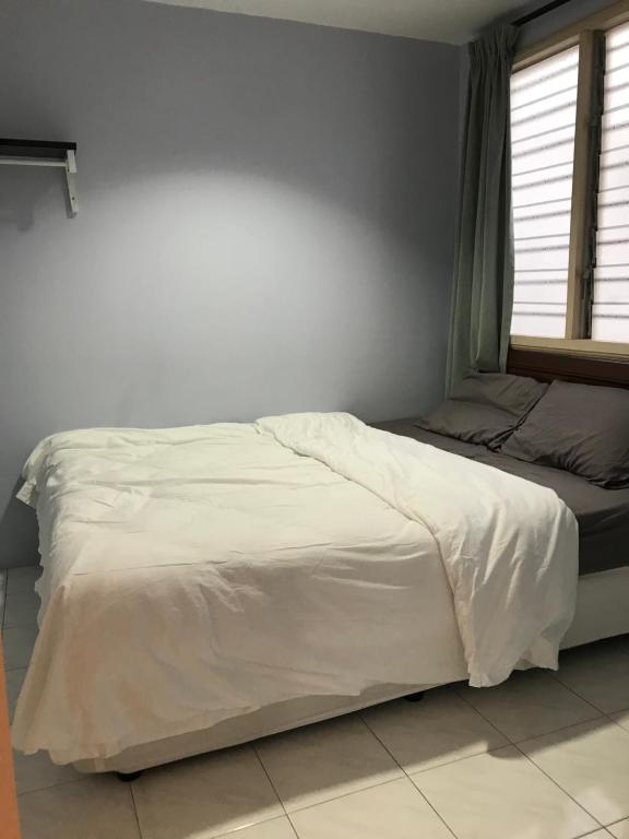 een bed met witte lakens en een raam in een slaapkamer bij Pangkor Coralbay Resort Room 208 apartment in Pangkor