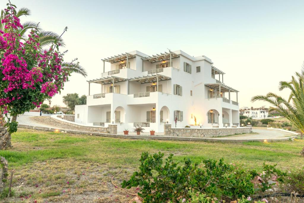 a large white house with a yard at Konstantinos in Adamas