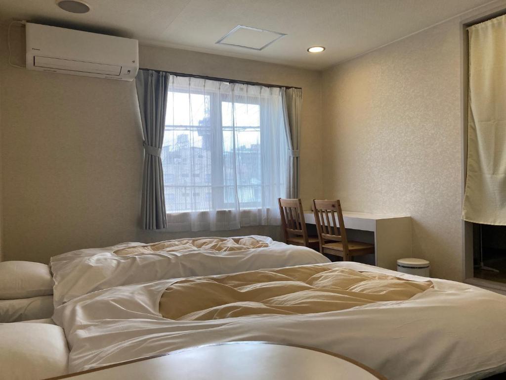 Postel nebo postele na pokoji v ubytování J-Hoppers Beppu Guesthouse ジェイホッパーズ別府ゲストハウス