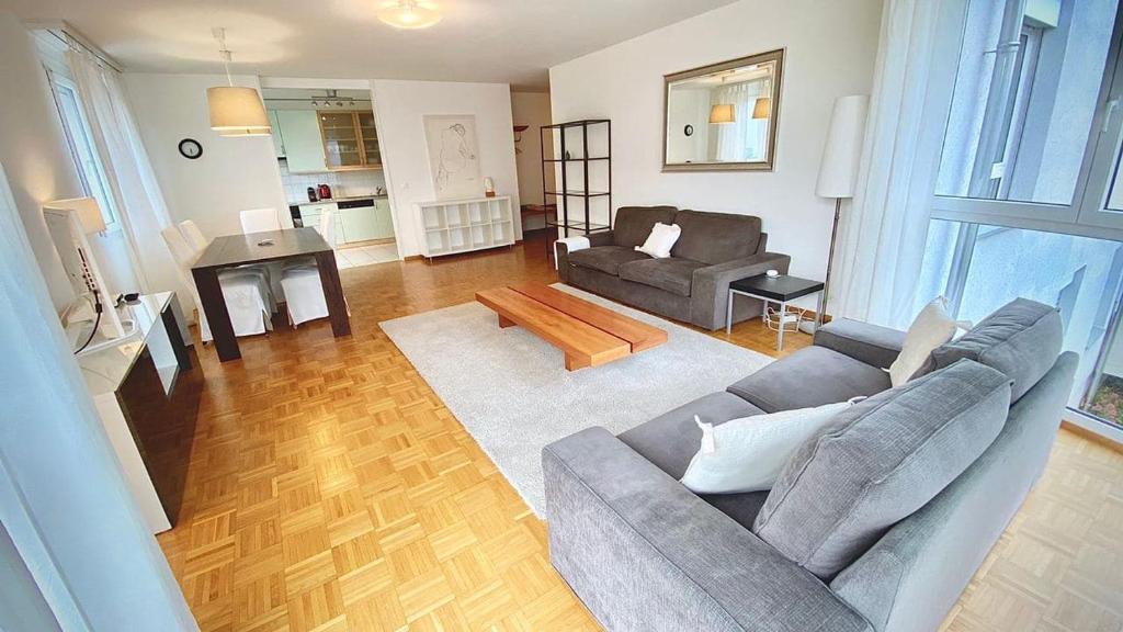 a living room with a couch and a table at Close to the lake and very spacious 3 bedroom in Lausanne