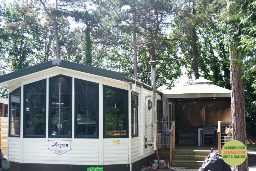 una casa pequeña con porche y cenador en Chalet/Caravan Camping Resort Heische Tip Zeeland en Zeeland