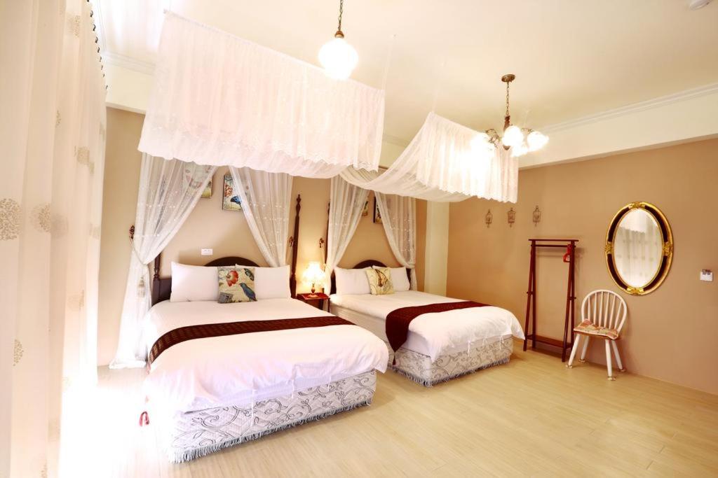 a bedroom with two beds and a mirror at Locking B&amp;B台東民宿 in Taitung City