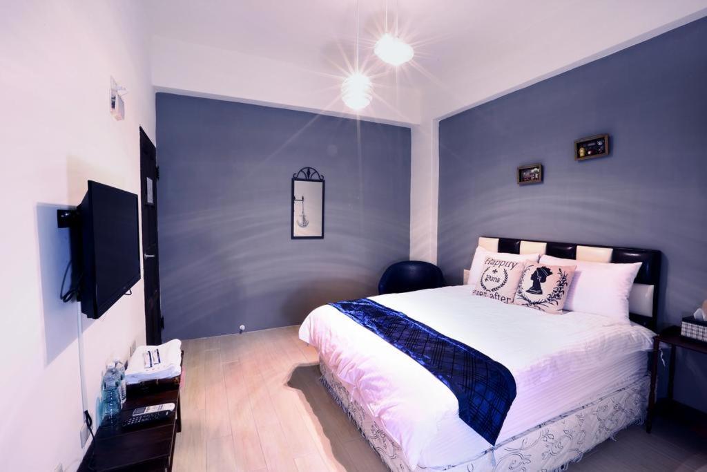 a bedroom with a large bed with a blue wall at Locking B&amp;B台東民宿 in Taitung City