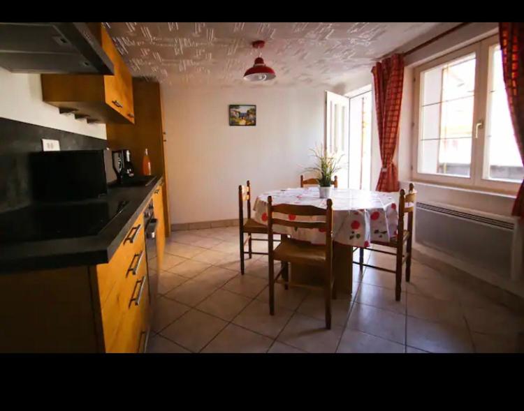 una cucina e una sala da pranzo con tavolo e sedie di gite du heidenberg a Osenbach