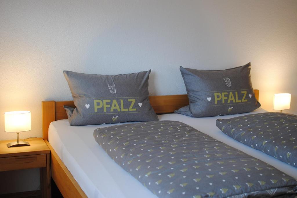 two beds with blue pillows in a room at Ferienhaus Rauwolf in Roschbach