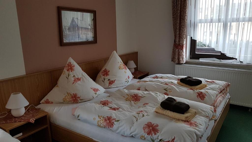 ein Schlafzimmer mit 2 Betten und Handtüchern darauf in der Unterkunft Hotel-Pension Flechsig in Hartmannsdorf