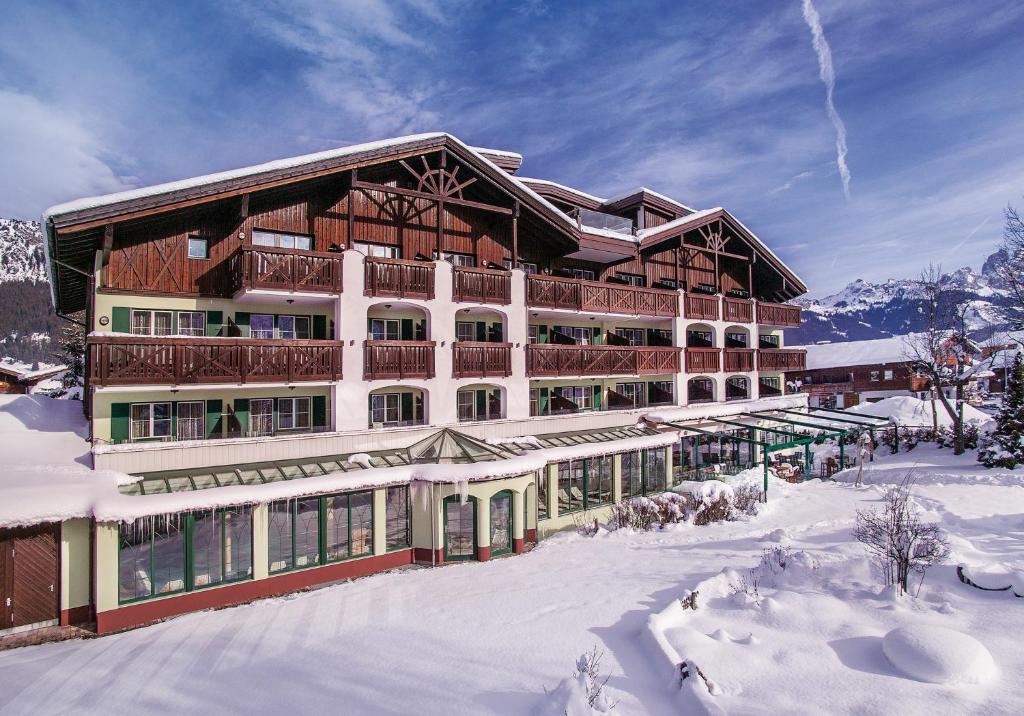 ein großes Gebäude im Schnee mit schneebedecktem Boden in der Unterkunft Hotel Sägerhof in Tannheim