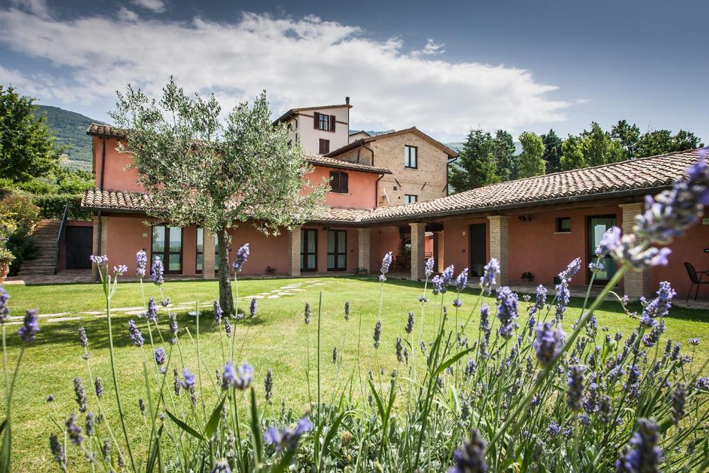 een huis met paarse bloemen ervoor bij Appartamenti Poggio Fiorito in Assisi