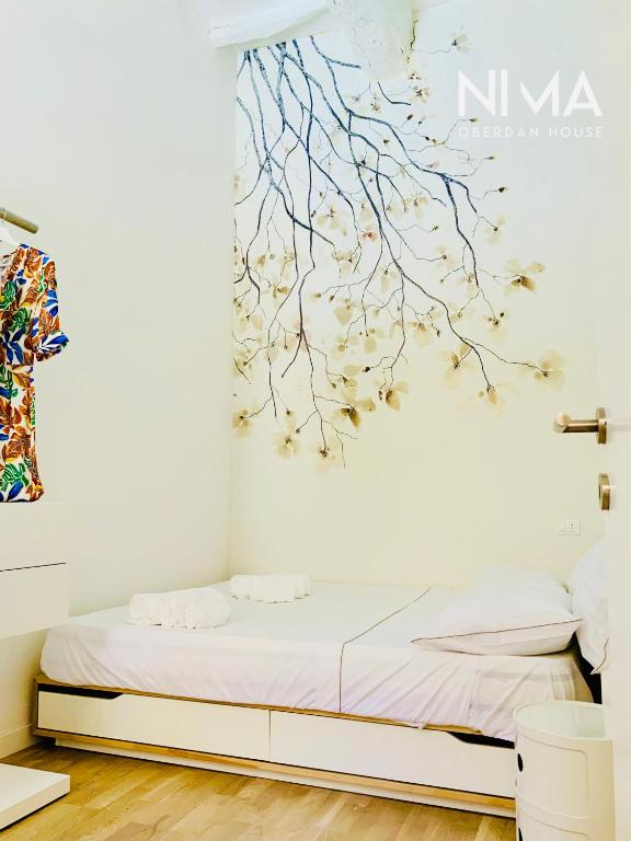 a bedroom with a bed with a painting on the wall at Nima Oberdan House in Perugia
