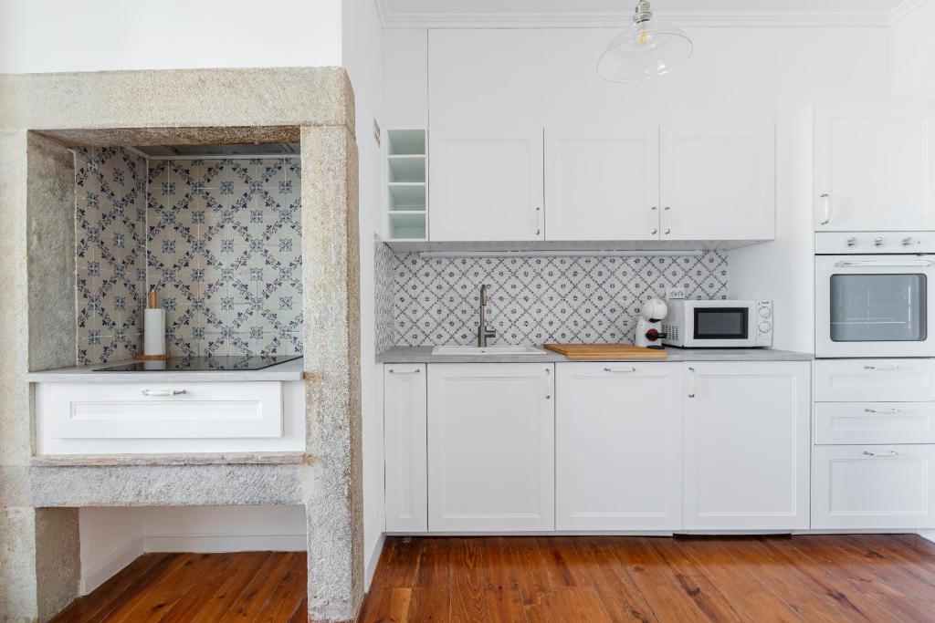 cocina blanca con armarios blancos y microondas en White & Blue Vintage Home in Graça en Lisboa