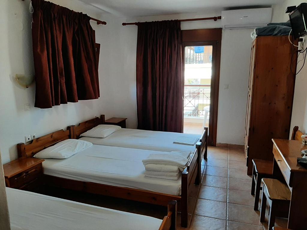 a bedroom with two beds and a window at Hotel Kosmas in Sarti