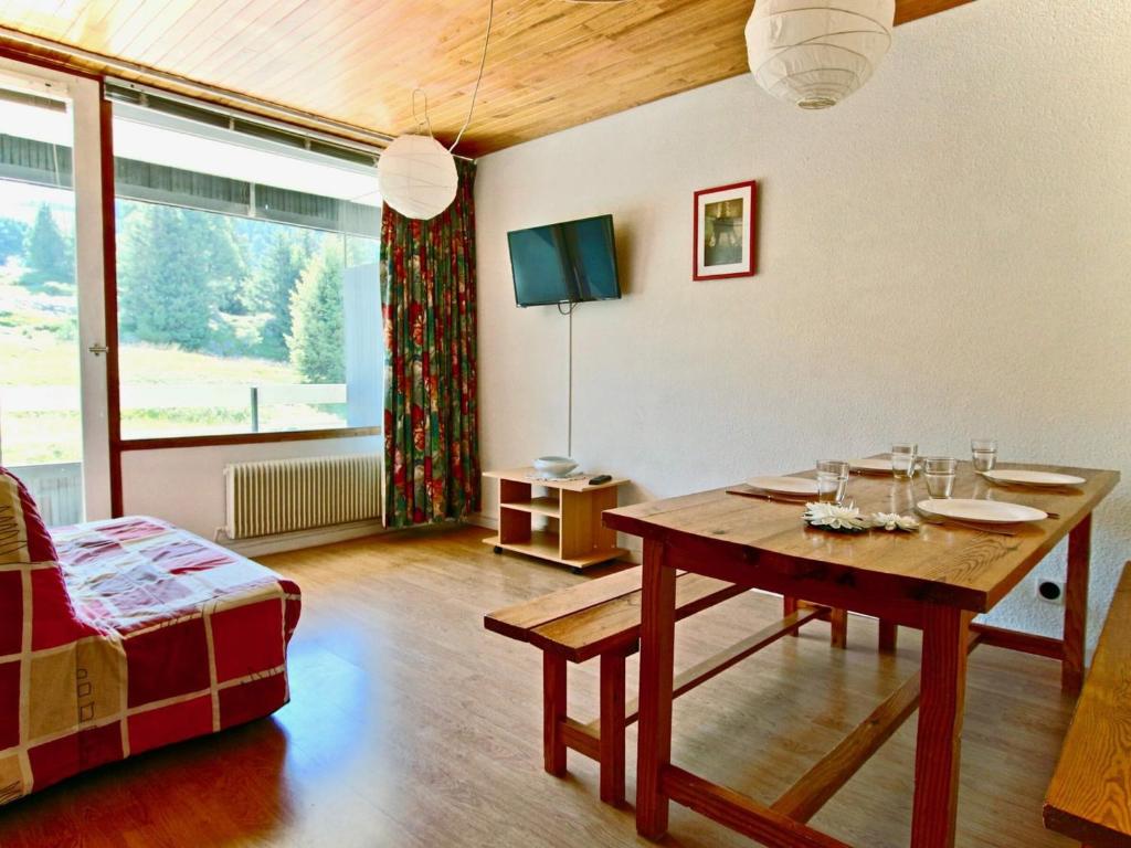a living room with a table and a couch at Studio Chamrousse, 1 pièce, 4 personnes - FR-1-340-47 in Chamrousse