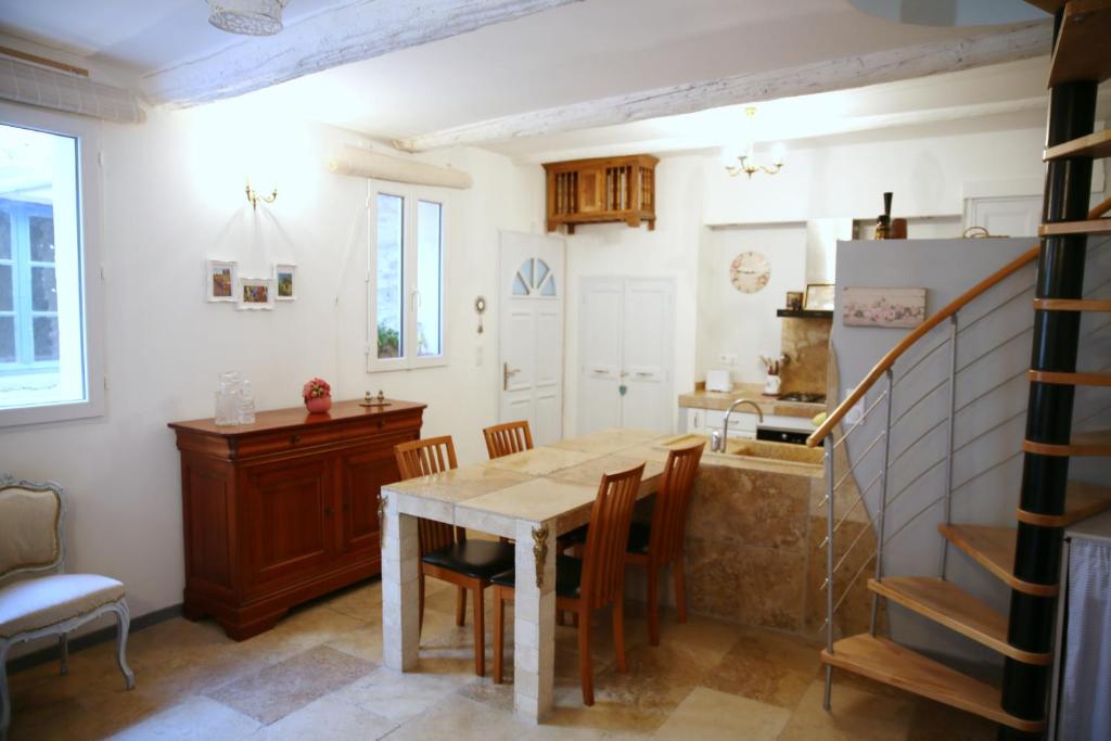 a kitchen and dining room with a table and chairs at Le Bastidon de Louis, L'Isle sur la Sorgue in LʼIsle-sur-la-Sorgue